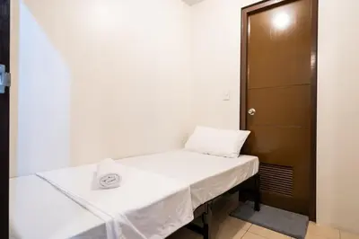 a small room with a bed and a door at Florence Mc Kinley Spacious 2 Bedroom, 2 balcony nr Mall, T3 airport in Manila