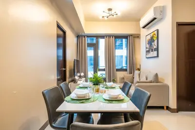 a dining room with a table and chairs at Florence Mc Kinley Spacious 2 Bedroom, 2 balcony nr Mall, T3 airport in Manila