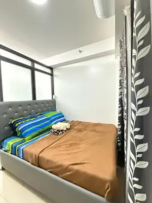 a bedroom with a bed with a metal headboard at LJ&LUNA Staycation in Manila