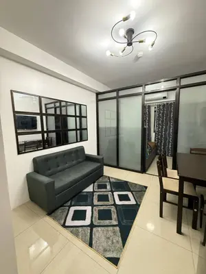 a living room with a black couch and a table at LJ&LUNA Staycation in Manila