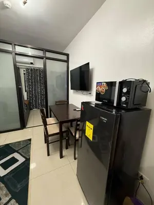 a kitchen and dining room with a table and a microwave at LJ&LUNA Staycation in Manila