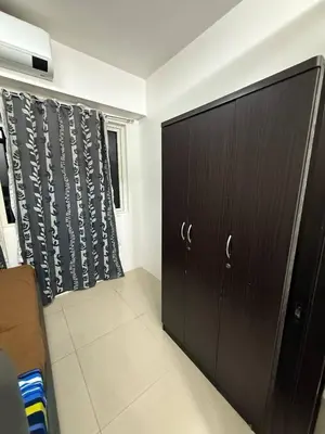 a dark wooden cabinet in a room with a curtain at LJ&LUNA Staycation in Manila
