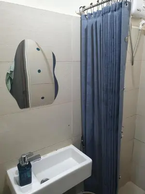 a bathroom with a sink and a shower curtain at Elevated cozy loft studio in Manila