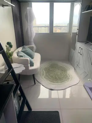 a small living room with a chair and a rug at Elevated cozy loft studio in Manila