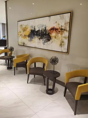 a waiting room with chairs and tables and a painting at 81 Newport Studio C5 5i near NAIA T3 Pool and Balcony in Manila