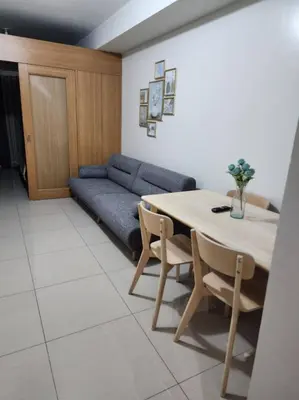 a living room with a table and a couch at 1BR with Netflix in Shell Residences Pasay in Manila