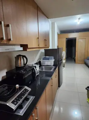 a kitchen with a stove and a sink and a refrigerator at 1BR with Netflix in Shell Residences Pasay in Manila
