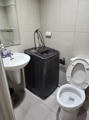 a bathroom with a trash can and a toilet and a sink at 1BR with Netflix in Shell Residences Pasay in Manila