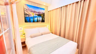 a small bedroom with a bed and a painting on the wall at Goldleaf Suite at Red Residences with Balcony in Prime Makati Location in Manila