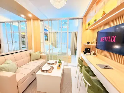 a living room with a couch and a tv at Goldleaf Suite at Red Residences with Balcony in Prime Makati Location in Manila