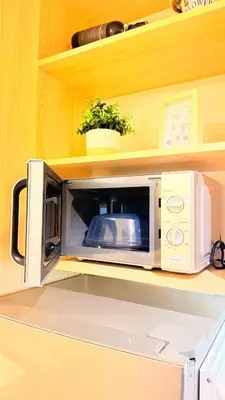 a microwave sitting on top of a shelf at Goldleaf Suite at Red Residences with Balcony in Prime Makati Location in Manila