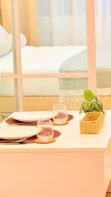 a table with plates and dishes on it with a bed at Goldleaf Suite at Red Residences with Balcony in Prime Makati Location in Manila