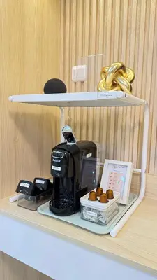 a shelf with a coffee maker and donuts on it at Goldleaf Suite at Red Residences with Balcony in Prime Makati Location in Manila