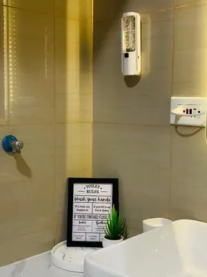 a bathroom with a laptop sitting on a toilet at Shore Urban Escape in Manila