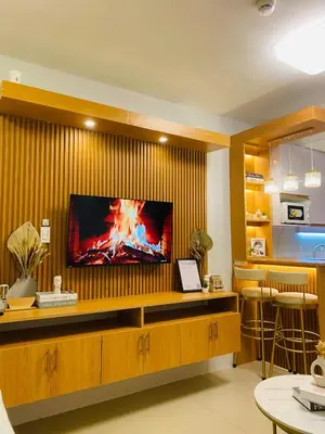 a living room with a flat screen tv on a wall at Shore Urban Escape in Manila