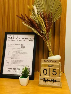a table with a sign and a calendar and a plant at Shore Urban Escape in Manila
