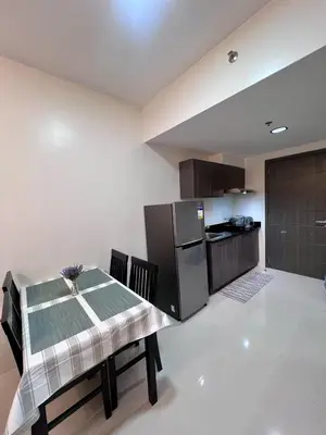 a kitchen and dining room with a table and a refrigerator at High and Cozy Vista Shaw in Manila