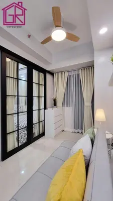 a living room with a couch and a ceiling fan at Stylish Modern Condo at Shore Residences MOA in Manila