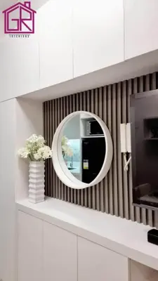 a round mirror on a wall in a room at Stylish Modern Condo at Shore Residences MOA in Manila
