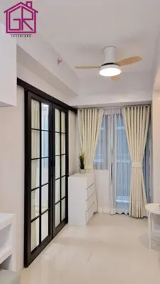 a living room with large windows and a ceiling fan at Stylish Modern Condo at Shore Residences MOA in Manila