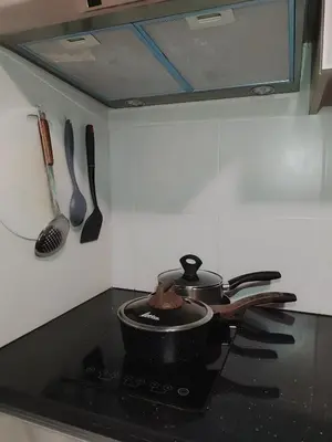 a pot on a stove in a kitchen with utensils at BP1637 Facing Pool with Balcony near MOA BP1637 in Manila