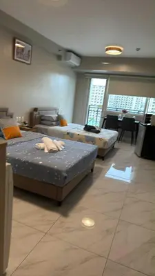 a room with three beds and a table and chairs at AyenStaycation in Manila