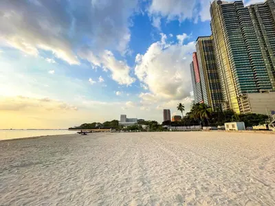 a sandy beach with tall buildings in the background at Spacious 3BR near US Embassy, Manila Ocean Park in Manila