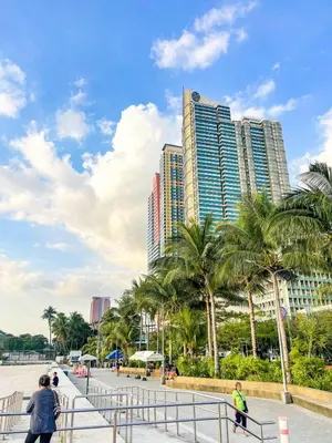 a group of people walking down a sidewalk with palm trees at Spacious 3BR near US Embassy, Manila Ocean Park in Manila