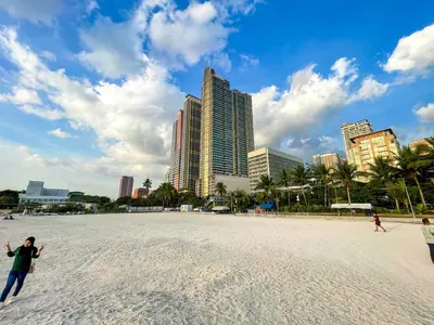 a group of people playing frisbee on a beach at Elegant 2BR Manila Bay Sunset near US Embassy in Manila