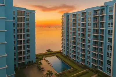a view of two tall buildings with a sunset in the background at Lovely 1BR w Sunset near Solaire, Okada, Airport in Manila