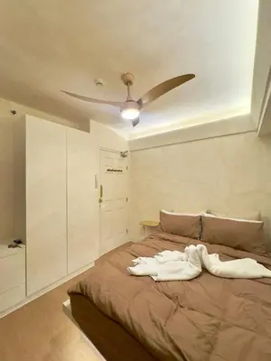 a bedroom with a bed with a ceiling fan at Taguig, near BGC Staycation in Manila