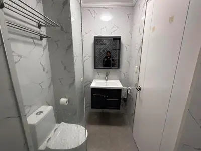 a bathroom with a sink and a person in a mirror at Stunning flat in Alabang in Manila