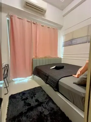 a bedroom with a bed with a window and a rug at Cozy Couple Room near mall of asia in Manila
