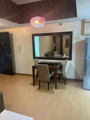 a dining room with a table and chairs and a mirror at Cozy Avant BGC 1Br Sleeps 4 in Manila