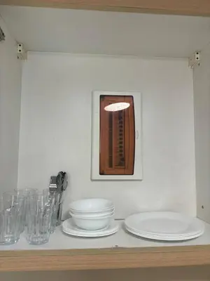 a counter with plates and bowls on a shelf at Cozy Avant BGC 1Br Sleeps 4 in Manila
