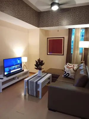 a living room with a couch and a flat screen tv at Cozy Avant BGC 1Br Sleeps 4 in Manila