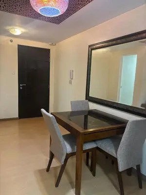 a dining room table with chairs and a mirror at Cozy Avant BGC 1Br Sleeps 4 in Manila