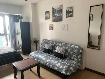a living room with a couch and a bed at Furnished Studio in Knightsbridge Residences in Manila