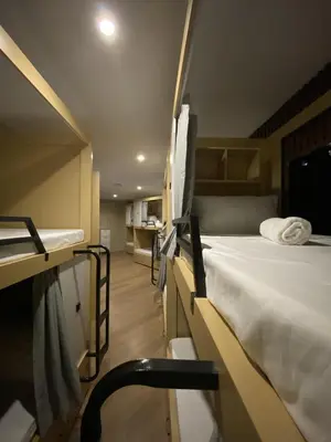 a room with two bunk beds and a chair in it at BuenaSentro Hostel in Manila