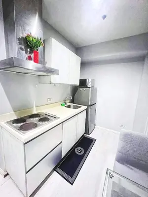 a small kitchen with a stove and a refrigerator at 2bedroom azure beach 5 in Manila