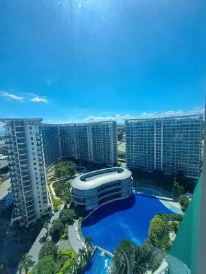 a building with a pool in front of some tall buildings at 2bedroom azure beach 5 in Manila