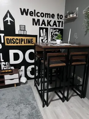 a black table and chairs in a room with a wall at Cozy Makati 2BR in CBD Ayala area with games, KTV, and Amazing Pools! in Manila