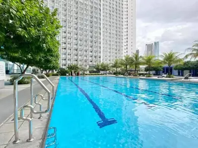 a large swimming pool in front of a large building at Cozy Makati 2BR in CBD Ayala area with games, KTV, and Amazing Pools! in Manila