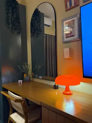 a desk with a red stool and a mirror at Serenity Stays at Red Residences in Manila