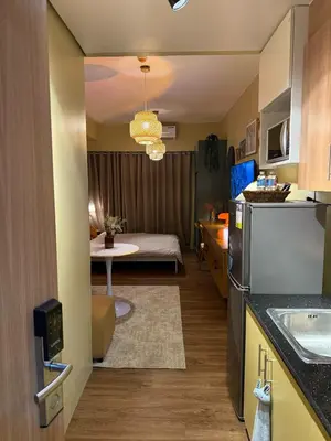 a kitchen and living room with a bed in a room at Serenity Stays at Red Residences in Manila