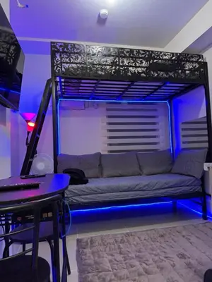 a bed with blue lights in a room with a couch at Urban Deca Tower Cubao - Affordable Condo Unit for Transient in Manila