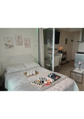 a bedroom with a bed with a tray of food on it at Azure Staycation by Leojen in Manila