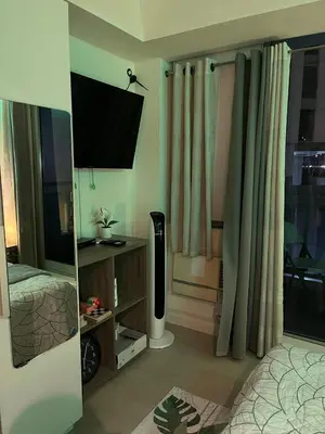 a room with a bed and a television in it at Azure Staycation by Leojen in Manila