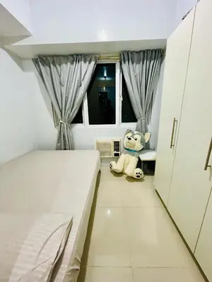 a teddy bear sitting in the corner of a bedroom at Simple Staycay in Manila