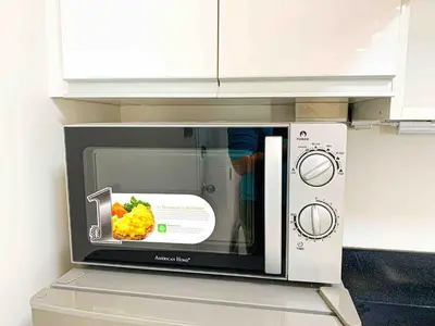 a microwave oven with a picture of food in it at 2BR Loft at Fort Victoria Condominium BGC in Manila